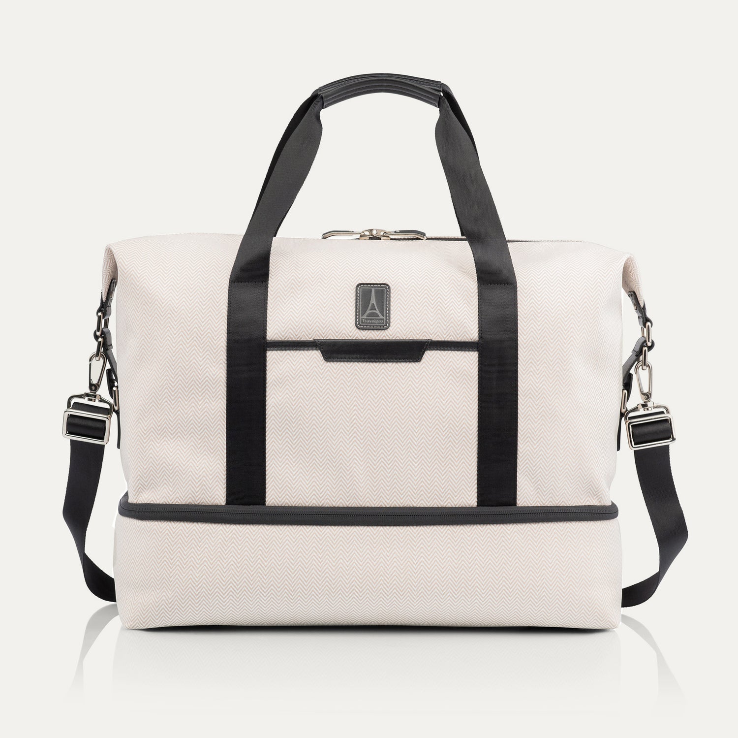 Travelpro x Travel + Leisure Drop-Bottom Weekender bag in White Sand with black accents, featuring a spacious main compartment, zippered bottom section, and removable shoulder strap