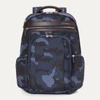 Travelpro Platinum® Elite Business Backpack in blue camo, featuring durable fabric, brown leather trim, multiple zippered compartments, and padded laptop sleeve