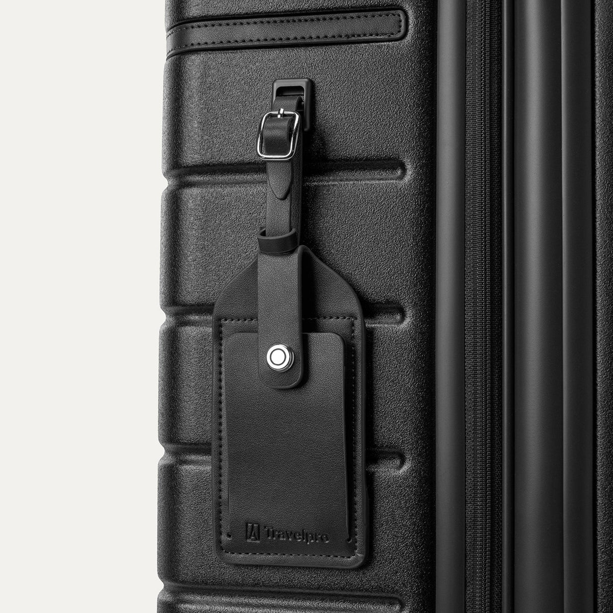 Close-up of the full-grain leather luggage tag on the Travelpro Platinum Reserve Compact Cabin Hardshell Spinner in Black Dust