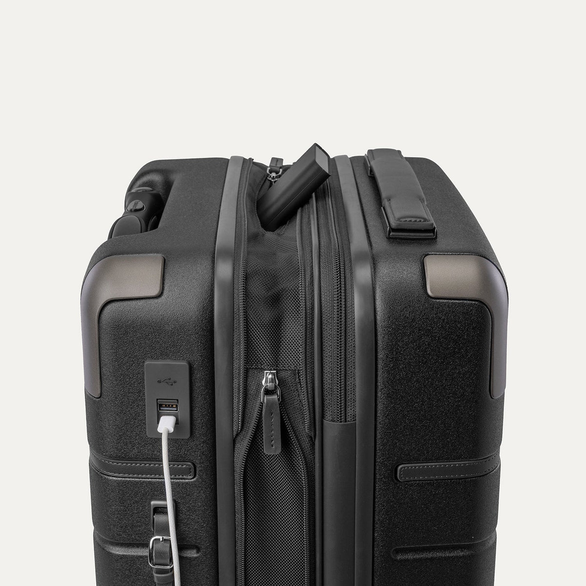 Charging cable plugged into the external USB port on the Travelpro Platinum Reserve Compact Cabin Hardshell Spinner in Black Dust