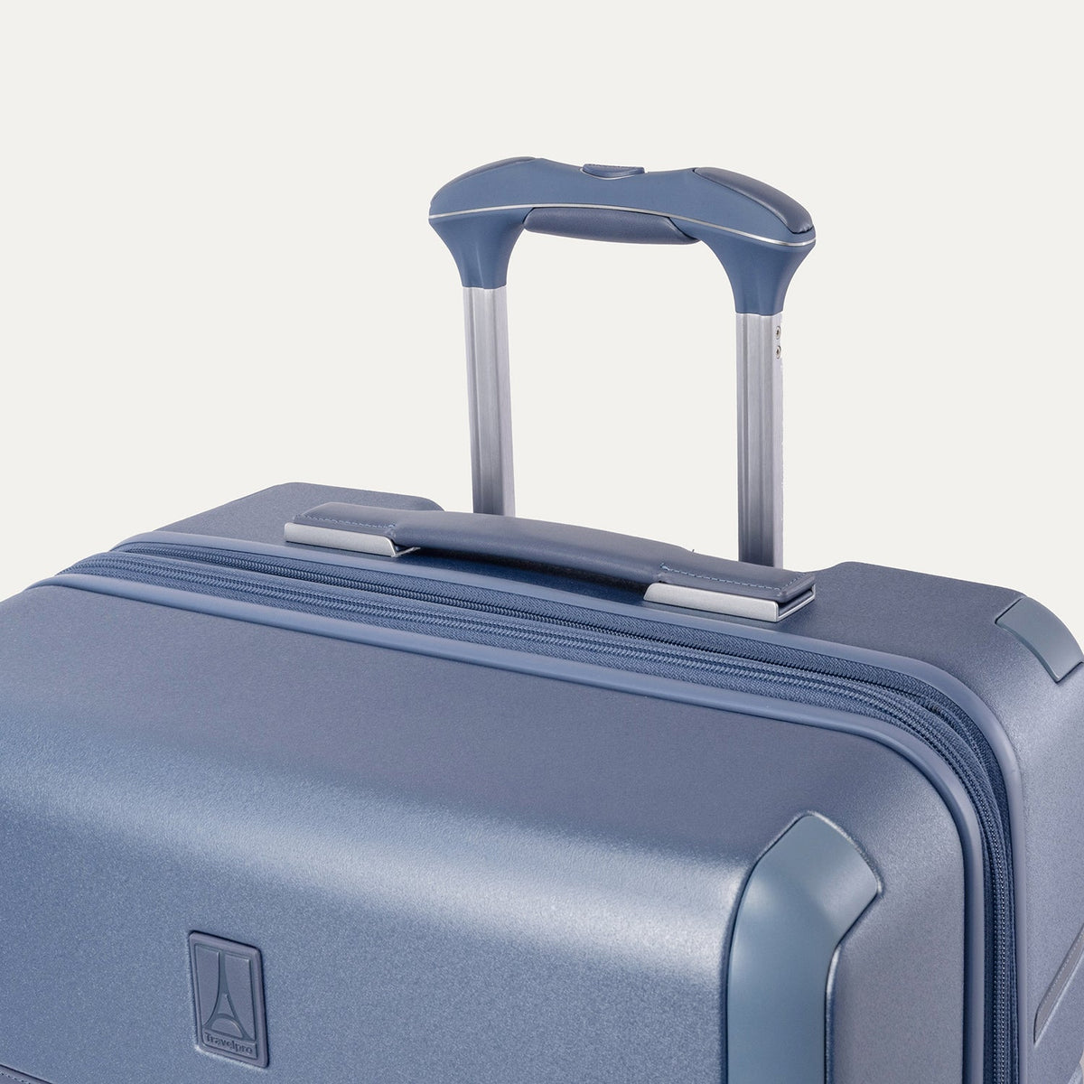 Close-up of the leather-wrapped top handle and PowerScope Lite extension handle on the Travelpro Platinum Reserve Compact Cabin Hardshell Spinner in Steel Blue