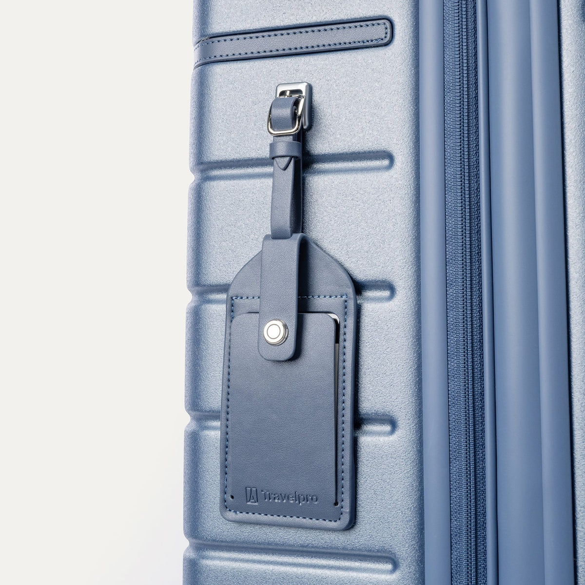 Close-up of the full-grain leather luggage tag on the Travelpro Platinum Reserve Compact Cabin Hardshell Spinner in Steel Blue