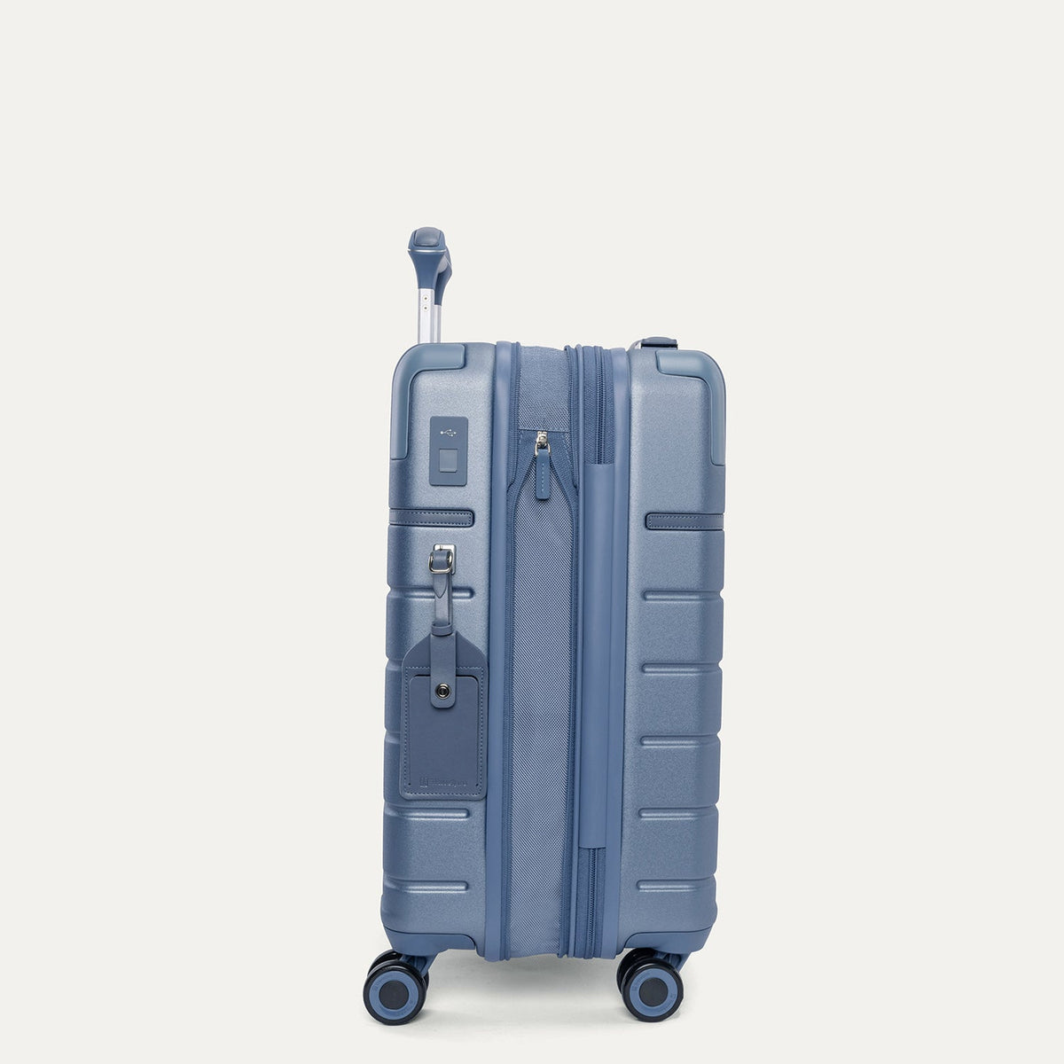 Side profile of the Travelpro Platinum Reserve Compact Cabin Hardshell Spinner in Steel Blue, expanded for extra packing space
