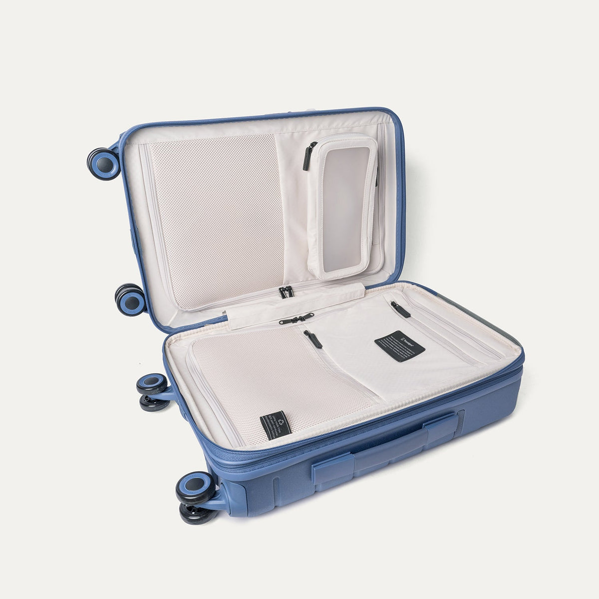 Open interior of the Travelpro Platinum Reserve Compact Cabin Hardshell Spinner in Steel Blue showing the zippered divider panel and dedicated pockets