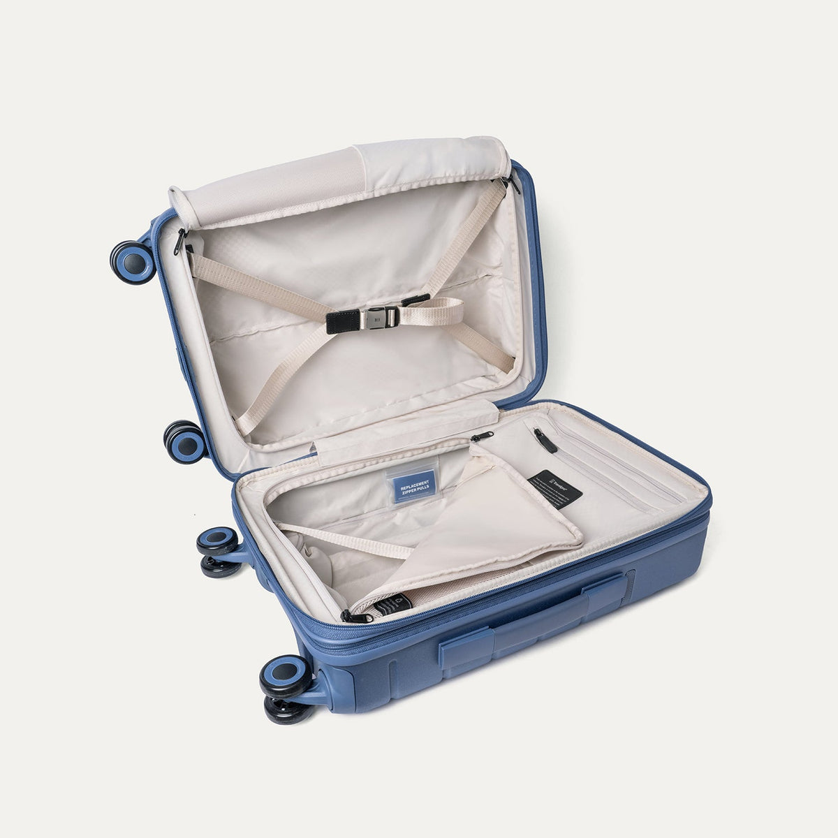 Open interior of the Travelpro Platinum Reserve Compact Cabin Hardshell Spinner in Steel Blue with hold-down straps