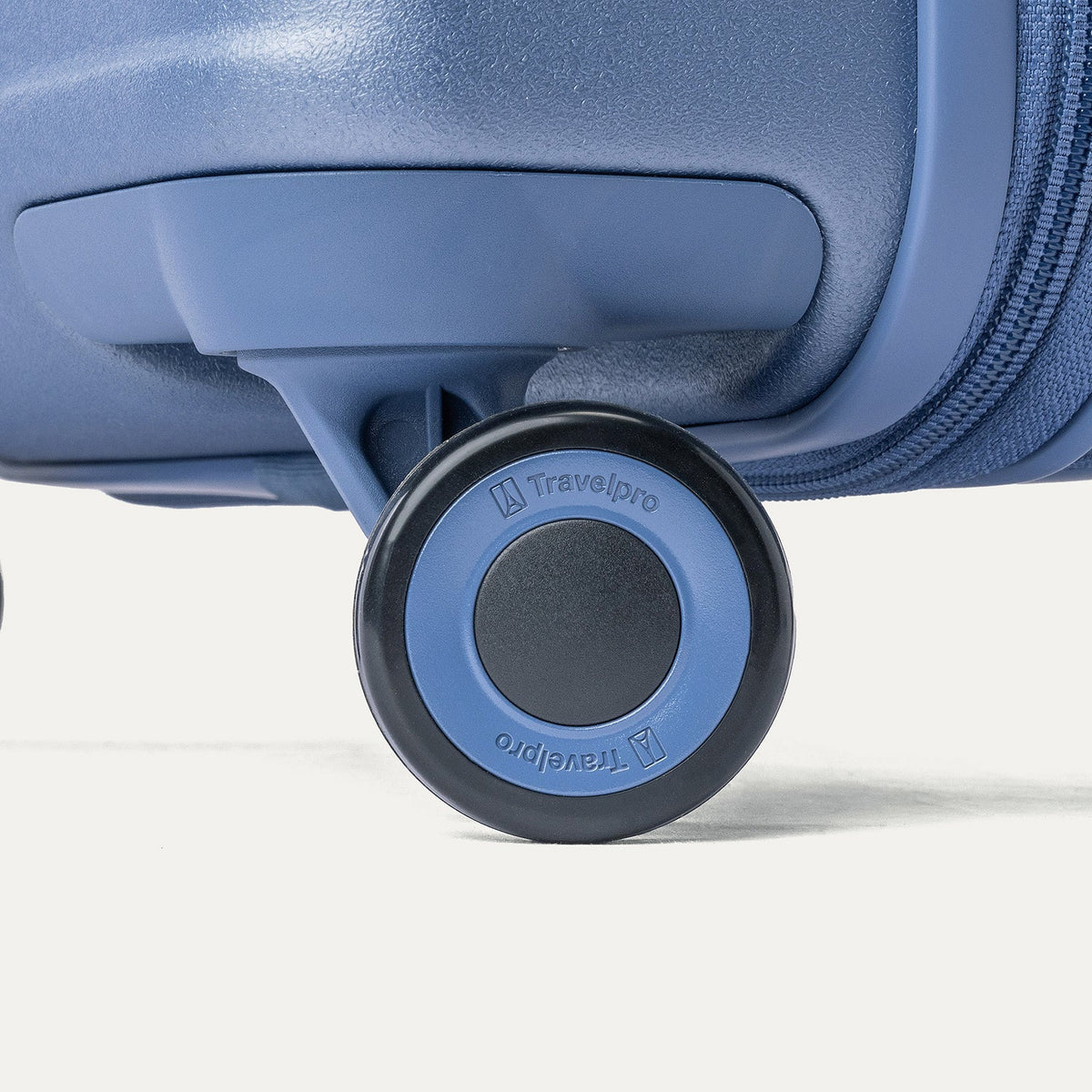 Close-up of a MagnaTrac self-aligning spinner wheel on the Travelpro Platinum Reserve Compact Cabin Hardshell Spinner in Steel Blue