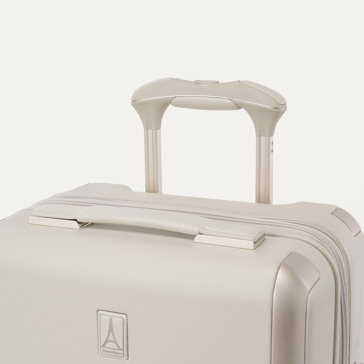 Close-up of the leather-wrapped top handle and PowerScope Lite extension handle on the Travelpro Platinum Reserve Compact Cabin Hardshell Spinner in Sandstone