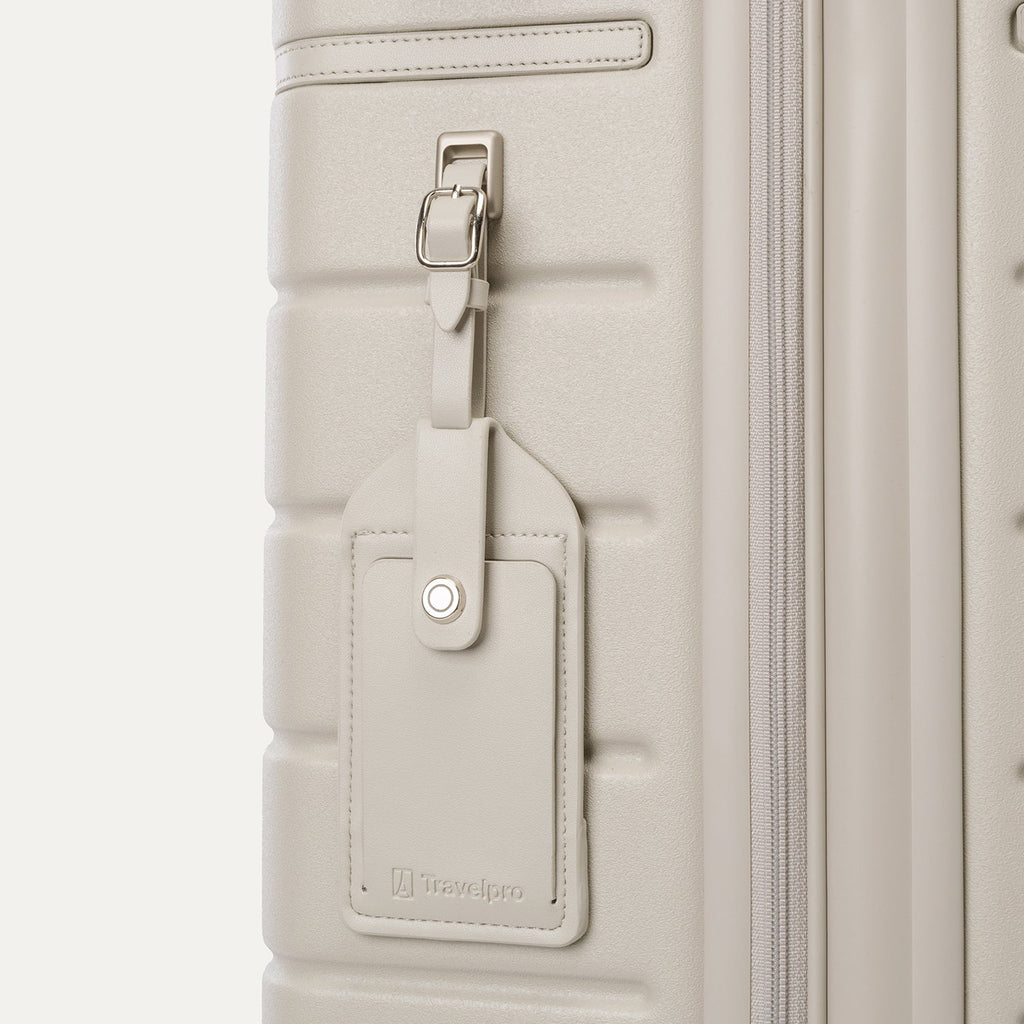 Close-up of the full-grain leather luggage tag on the Travelpro Platinum Reserve Compact Cabin Hardshell Spinner in Sandstone