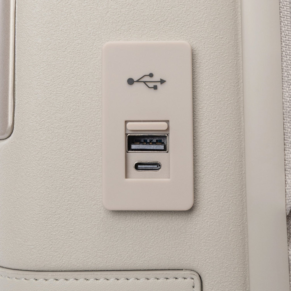 Close-up of the external USB-A and USB-C charging ports on the Travelpro Platinum Reserve Compact Cabin Hardshell Spinner in Sandstone