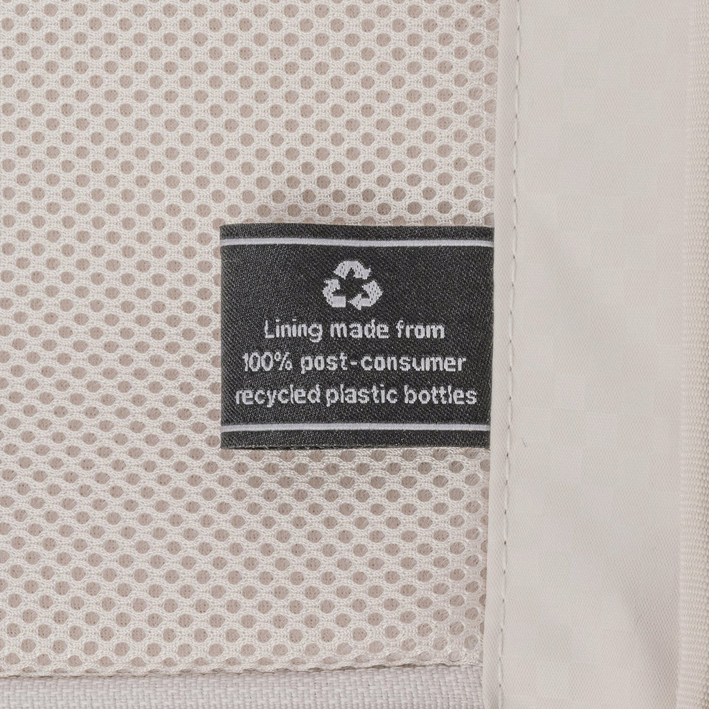 ECOFAB lining label inside the Travelpro Platinum Reserve Compact Cabin Hardshell Spinner in Sandstone, made from 100% post-consumer recycled plastic bottles