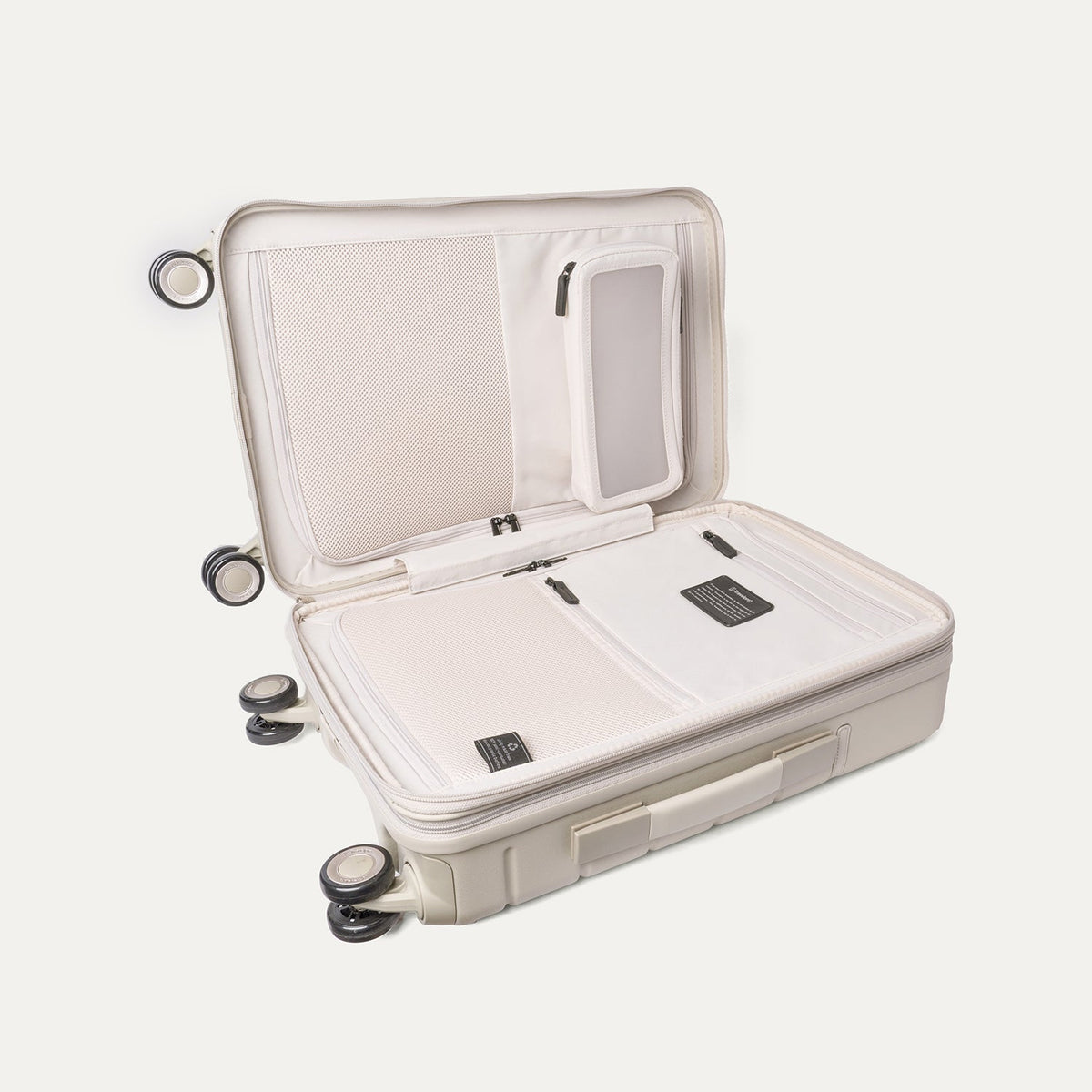 Open interior of the Travelpro Platinum Reserve Compact Cabin Hardshell Spinner in Sandstone showing the zippered divider panel and dedicated pockets