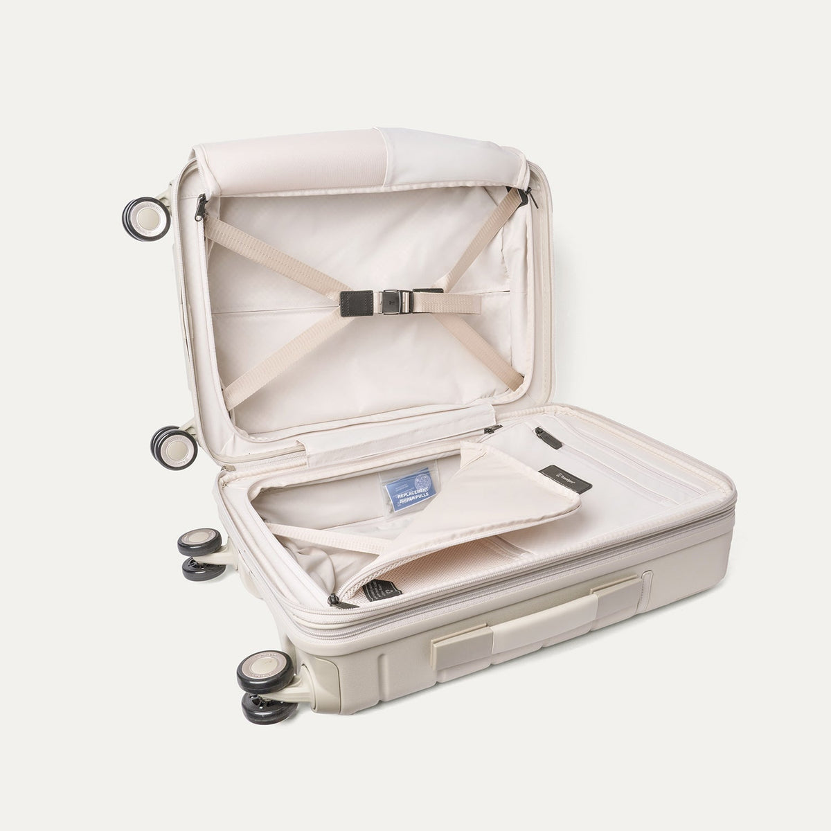 Open interior of the Travelpro Platinum Reserve Compact Cabin Hardshell Spinner in Sandstone with hold-down straps