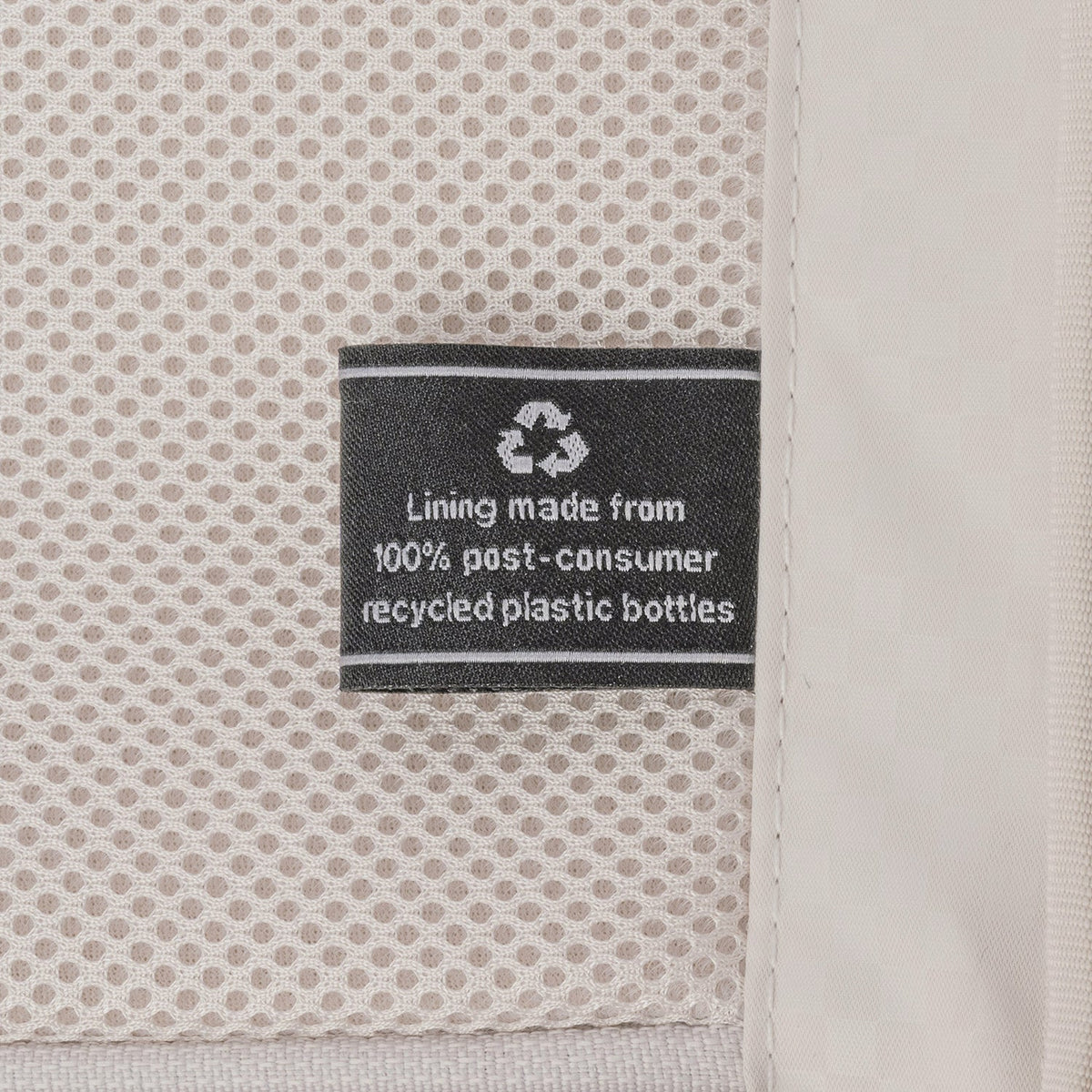 ECOFAB lining label inside the Travelpro Platinum Reserve Compact Cabin Hardshell Spinner in Midnight Trail, made from 100% post-consumer recycled plastic bottles
