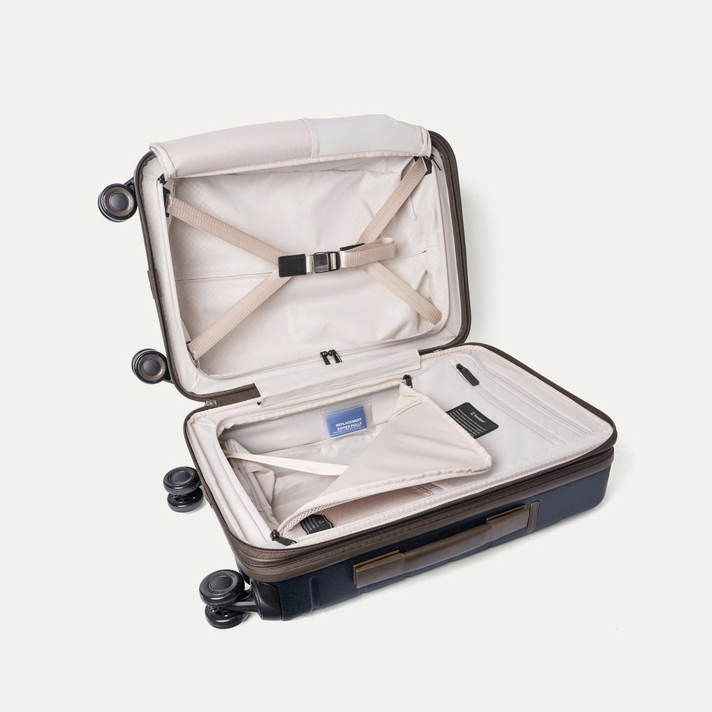 Open interior of the Travelpro Platinum Reserve Compact Cabin Hardshell Spinner in Midnight Trail with hold-down straps