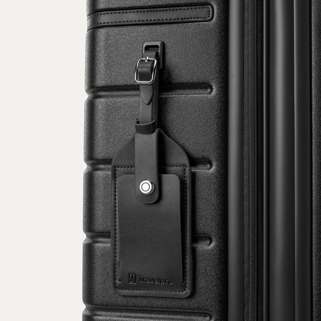 Close-up of the full-grain leather luggage tag on the Travelpro Platinum Reserve Medium Check-In Hardshell Spinner in Black Dust