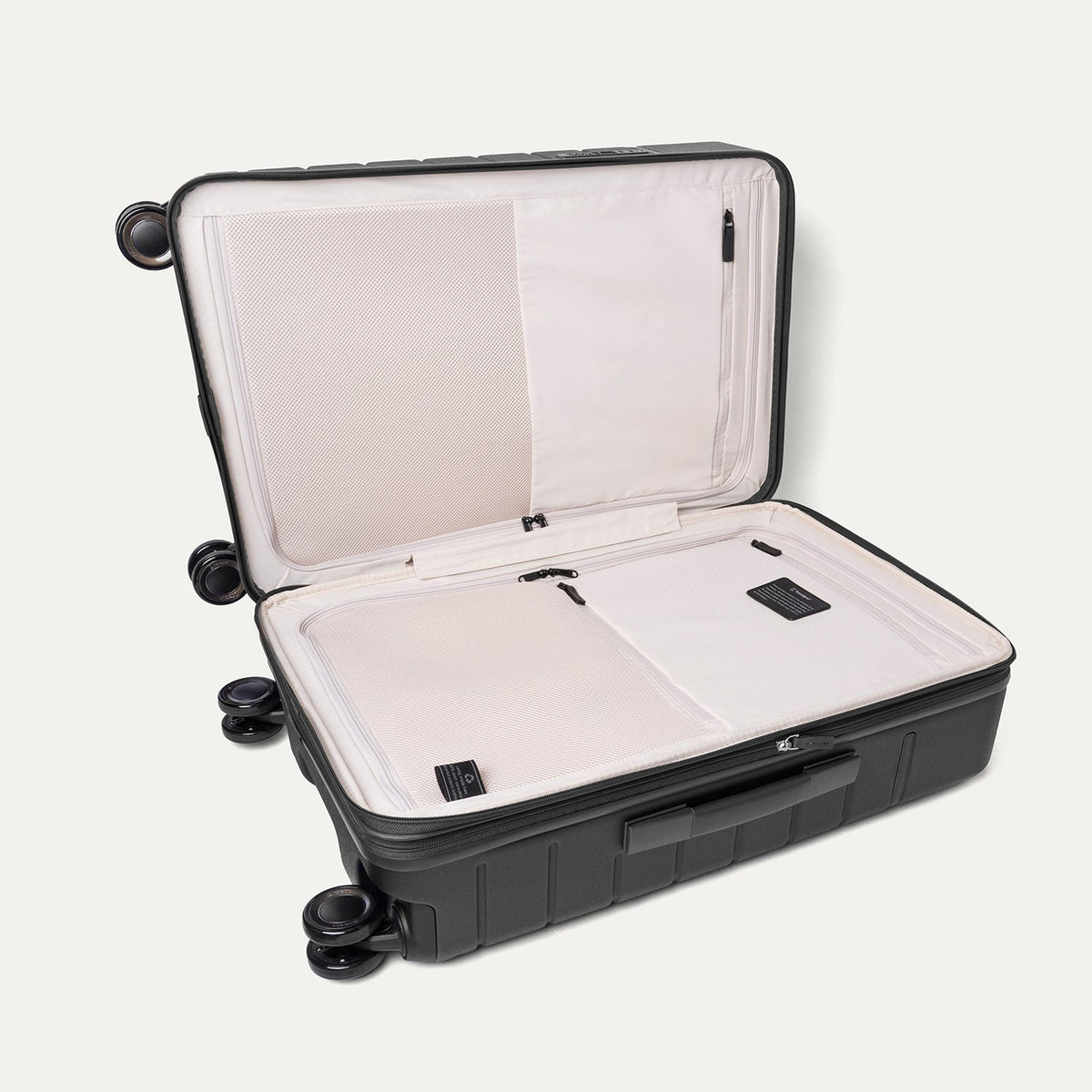 Open interior of the Travelpro Platinum Reserve Medium Check-In Hardshell Spinner in Black Dust showing the zippered divider panel and dedicated pockets