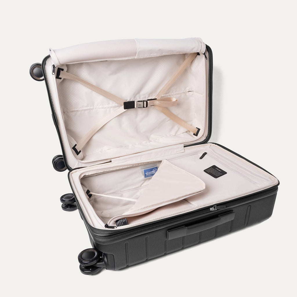 Open interior of the Travelpro Platinum Reserve Medium Check-In Hardshell Spinner in Black Dust with hold-down straps