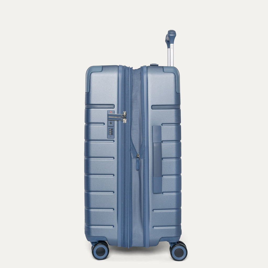Side profile of the Travelpro Platinum Reserve Medium Check-In Hardshell Spinner in Steel Blue, expanded for extra packing space