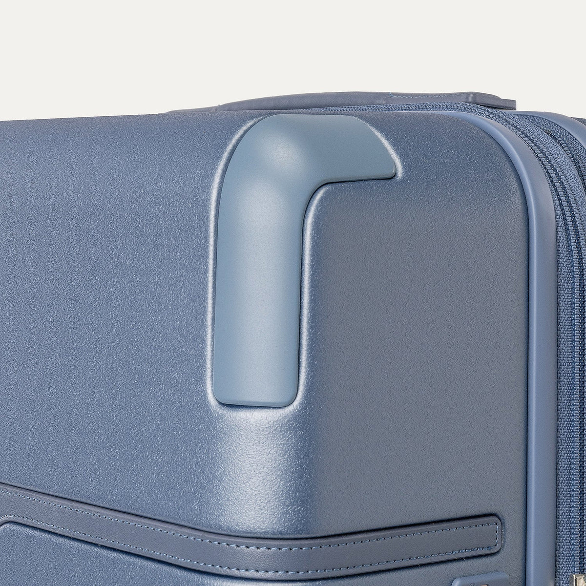Close-up of the zinc corner armour on the Travelpro Platinum Reserve Medium Check-In Hardshell Spinner in Steel Blue