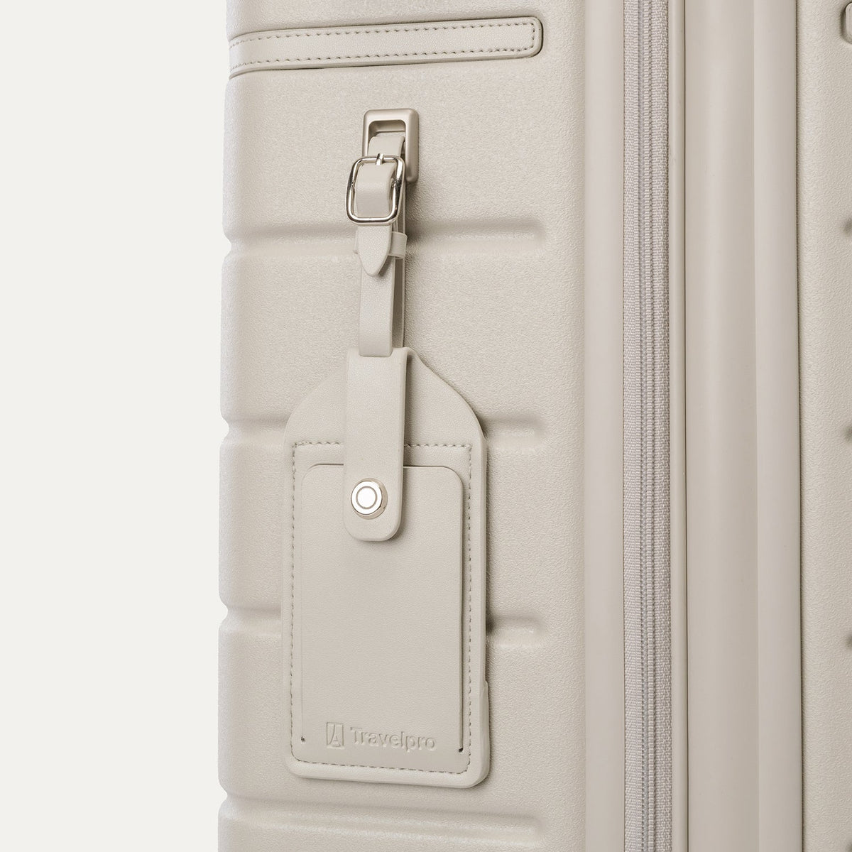 Close-up of the full-grain leather luggage tag on the Travelpro Platinum Reserve Medium Check-In Hardshell Spinner in Sandstone