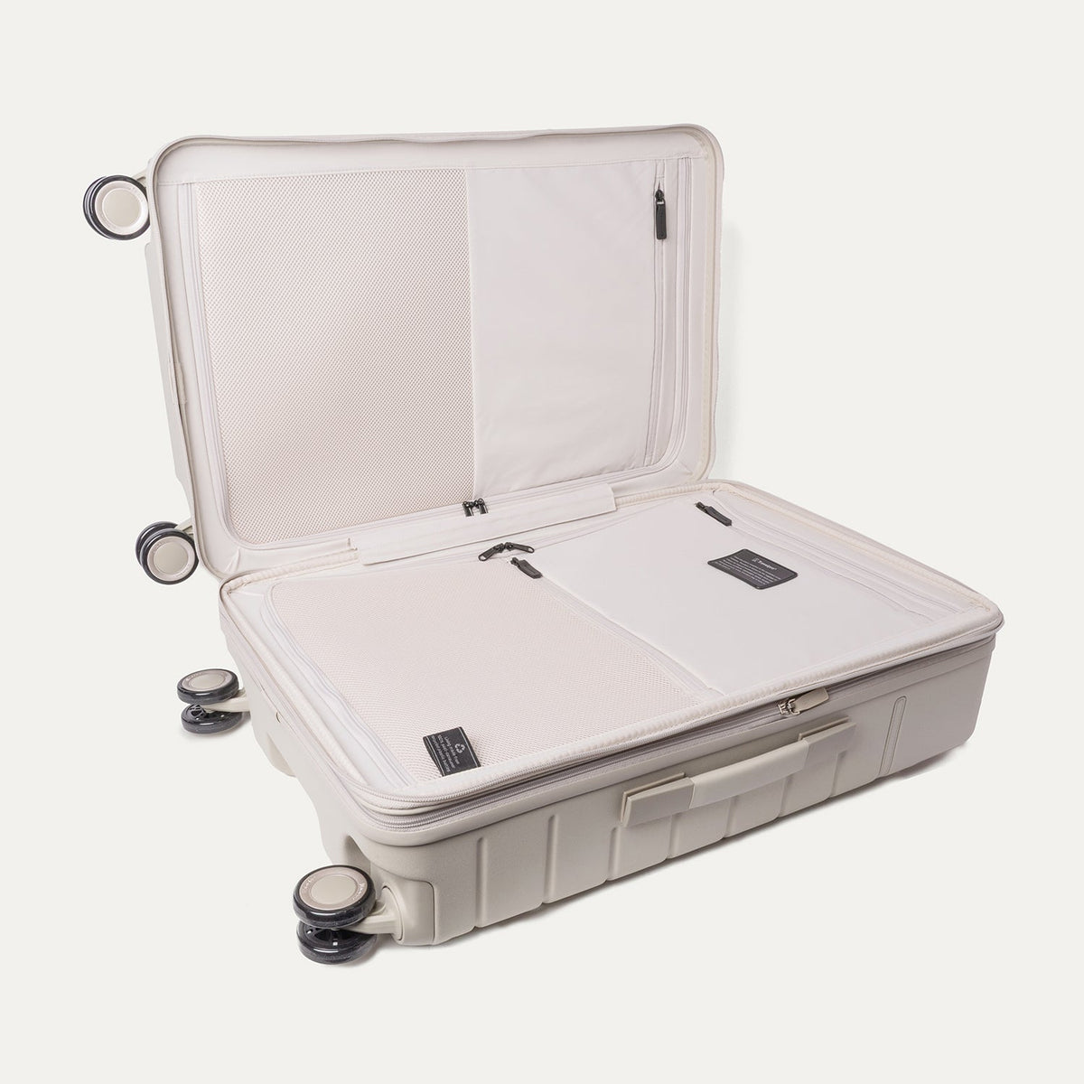 Open interior of the Travelpro Platinum Reserve Medium Check-In Hardshell Spinner in Sandstone showing the zippered divider panel and dedicated pockets