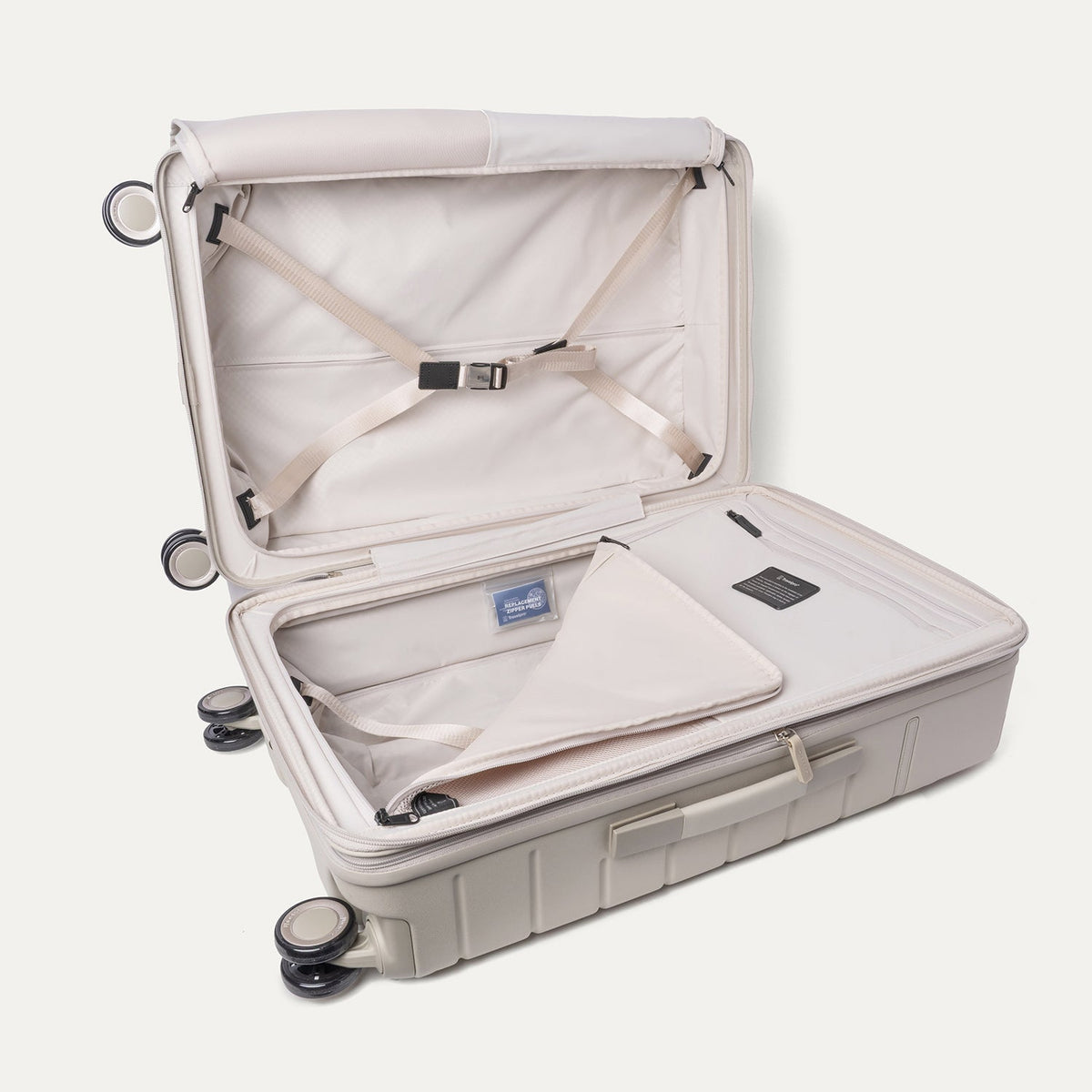 Open interior of the Travelpro Platinum Reserve Medium Check-In Hardshell Spinner in Sandstone with hold-down straps