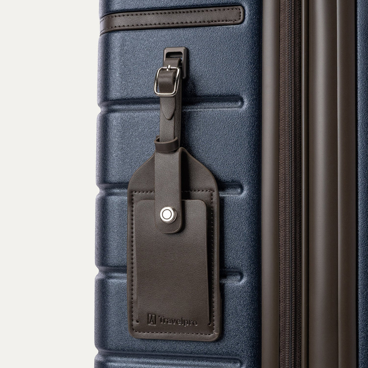 Close-up of the full-grain leather luggage tag on the Travelpro Platinum Reserve Medium Check-In Hardshell Spinner in Midnight Trail
