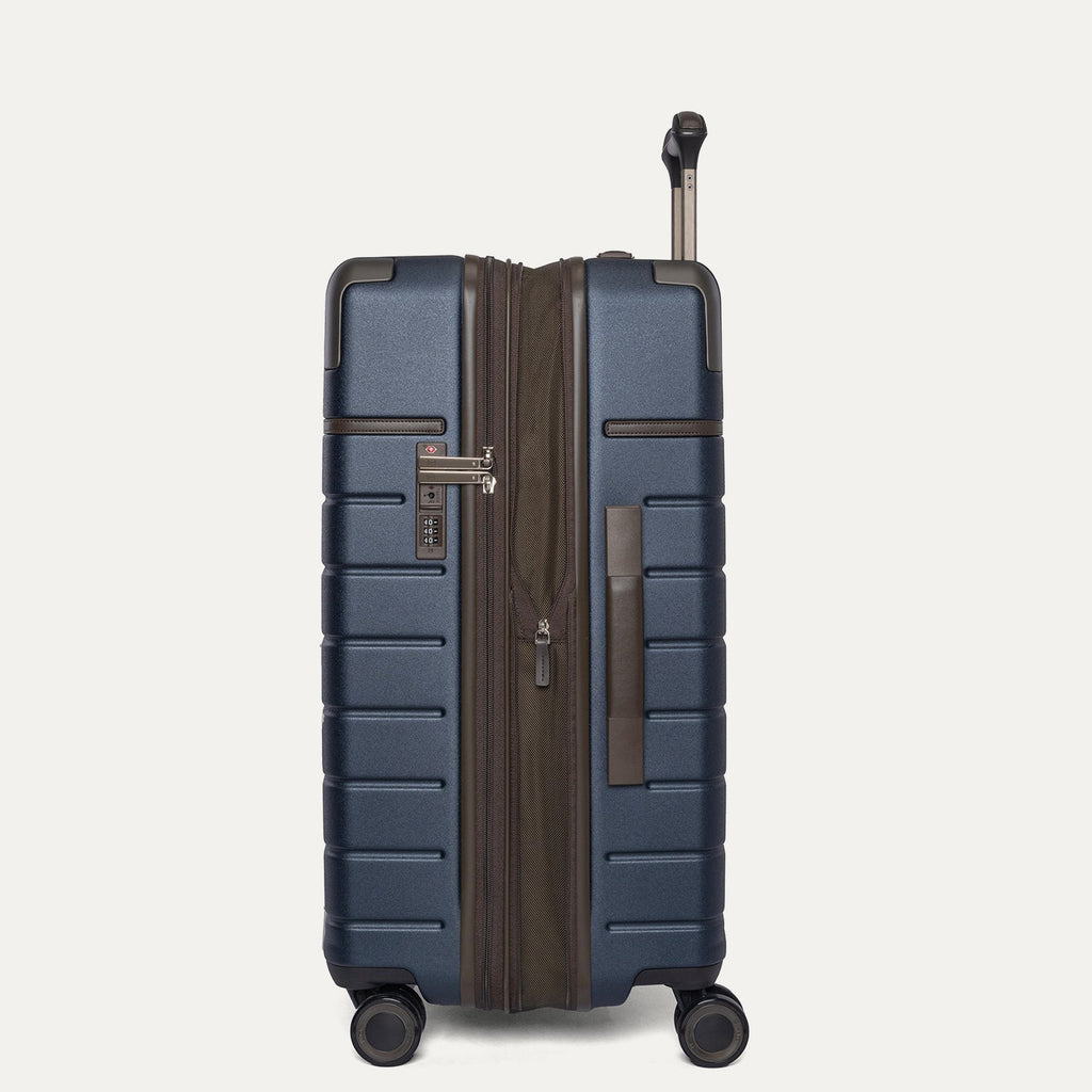 Side profile of the Travelpro Platinum Reserve Medium Check-In Hardshell Spinner in Midnight Trail, expanded for extra packing space
