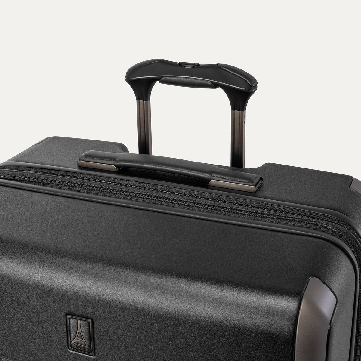 Close-up of the leather-wrapped top handle and PowerScope Lite extension handle on the Travelpro Platinum Reserve Large Check-In Hardshell Spinner in Black Dust