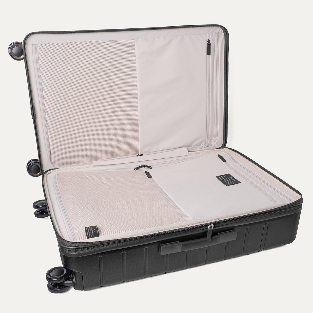 Open interior of the Travelpro Platinum Reserve Large Check-In Hardshell Spinner in Black Dust showing the zippered divider panel and dedicated pockets