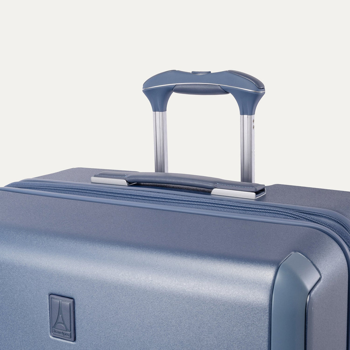 Close-up of the leather-wrapped top handle and PowerScope Lite extension handle on the Travelpro Platinum Reserve Large Check-In Hardshell Spinner in Steel Blue