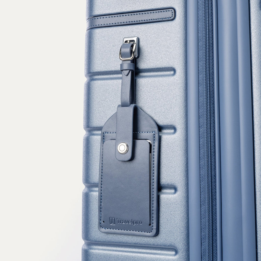 Close-up of the full-grain leather luggage tag on the Travelpro Platinum Reserve Large Check-In Hardshell Spinner in Steel Blue
