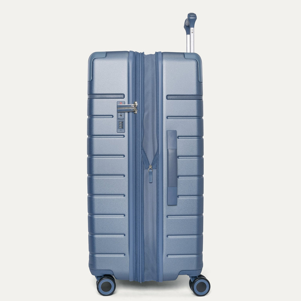 Side profile of the Travelpro Platinum Reserve Large Check-In Hardshell Spinner in Steel Blue, expanded for extra packing space