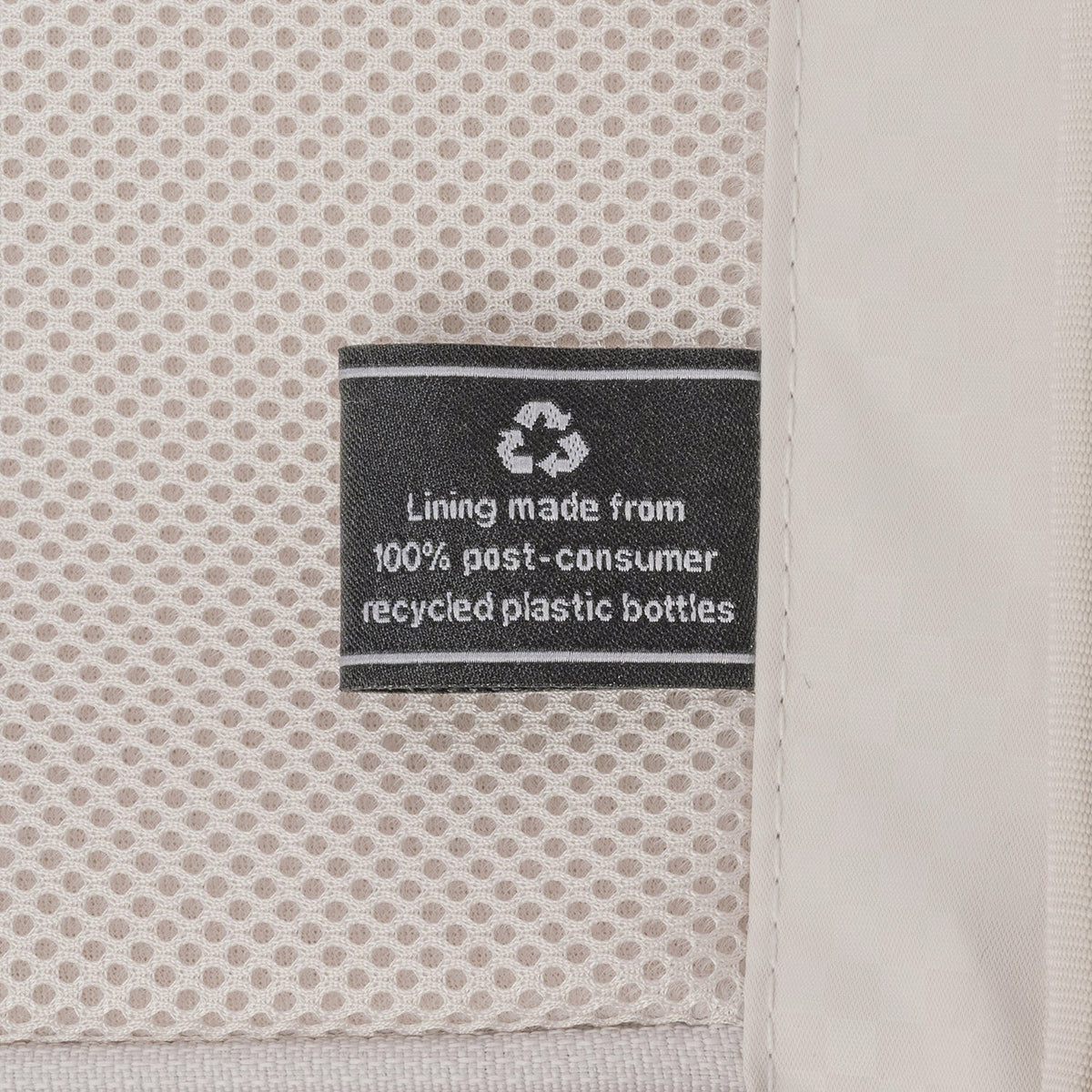 ECOFAB lining label inside the Travelpro Platinum Reserve Large Check-In Hardshell Spinner in Sandstone, made from 100% post-consumer recycled plastic bottles