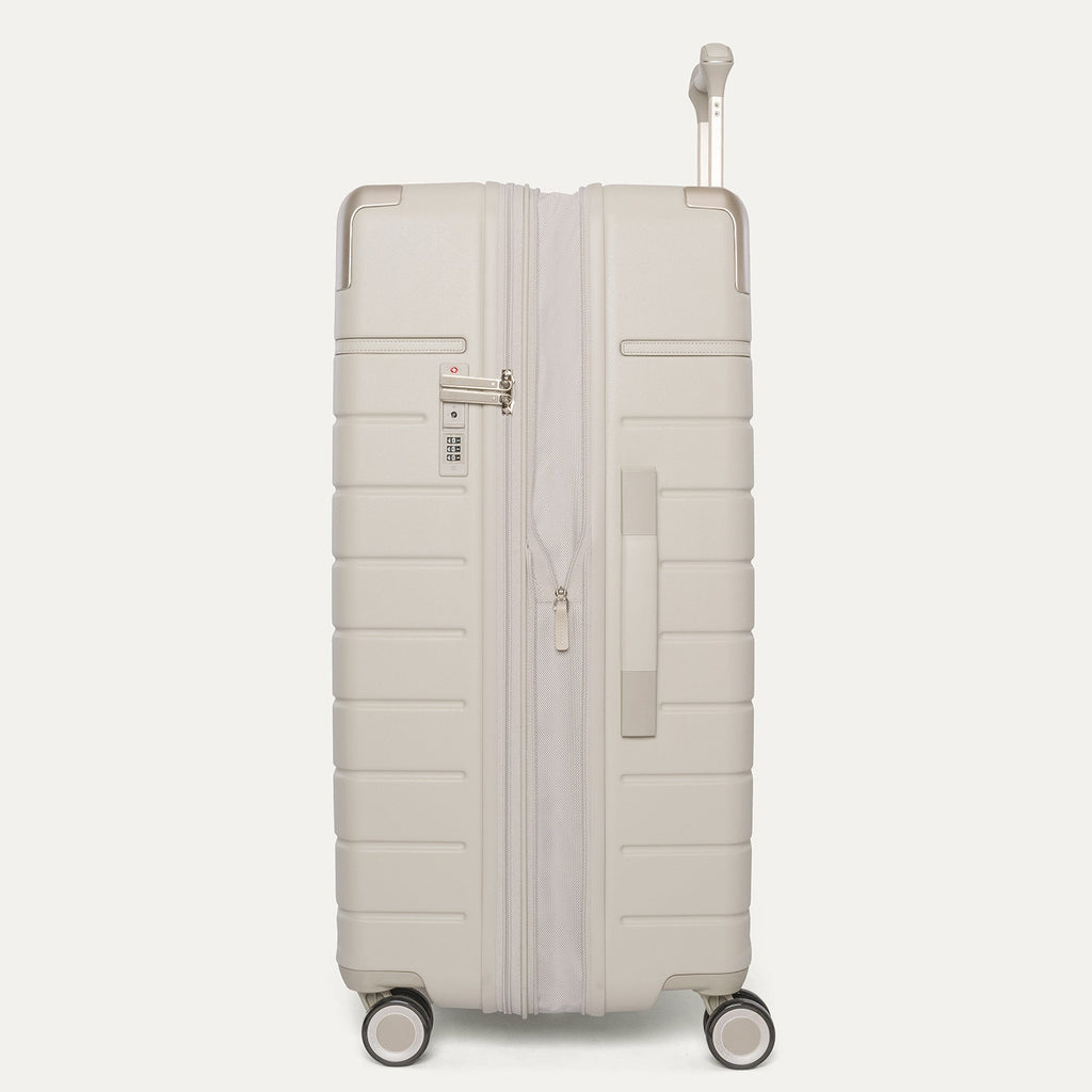 Side profile of the Travelpro Platinum Reserve Large Check-In Hardshell Spinner in Sandstone, expanded for extra packing space