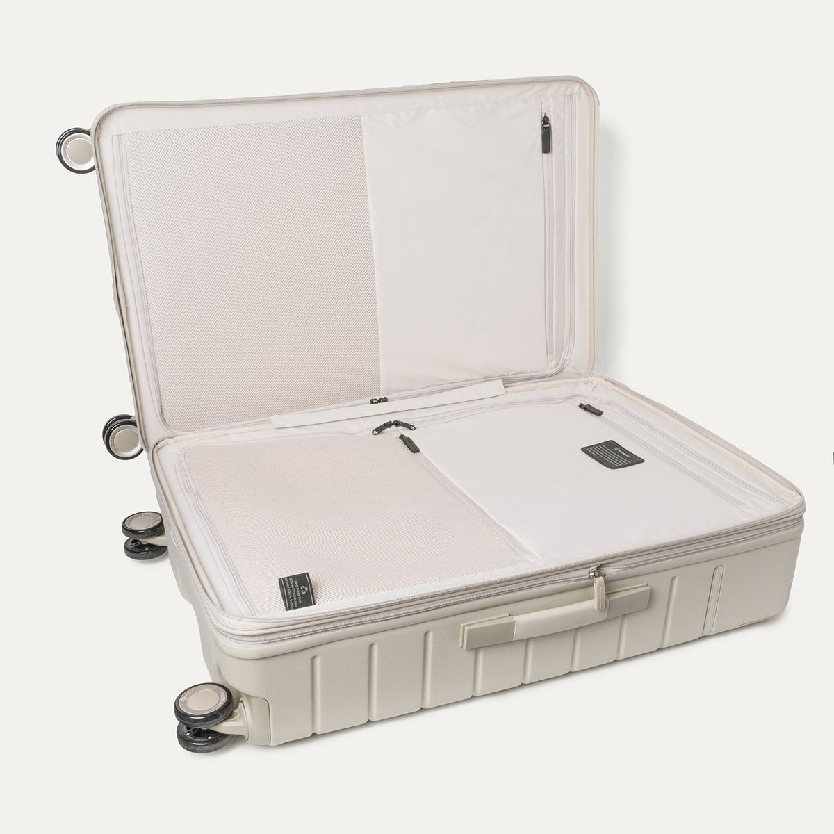 Open interior of the Travelpro Platinum Reserve Large Check-In Hardshell Spinner in Sandstone showing the zippered divider panel and dedicated pockets