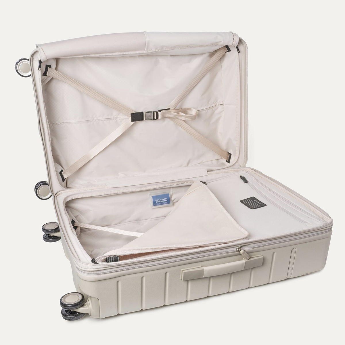 Open interior of the Travelpro Platinum Reserve Large Check-In Hardshell Spinner in Sandstone with hold-down straps