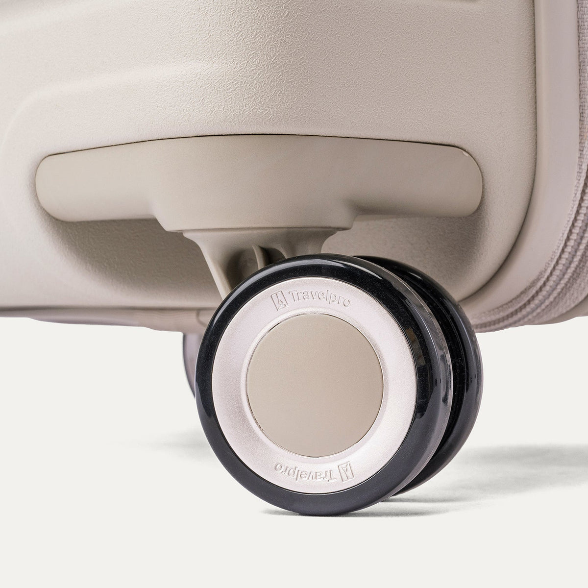 Close-up of a MagnaTrac self-aligning spinner wheel on the Travelpro Platinum Reserve Large Check-In Hardshell Spinner in Sandstone