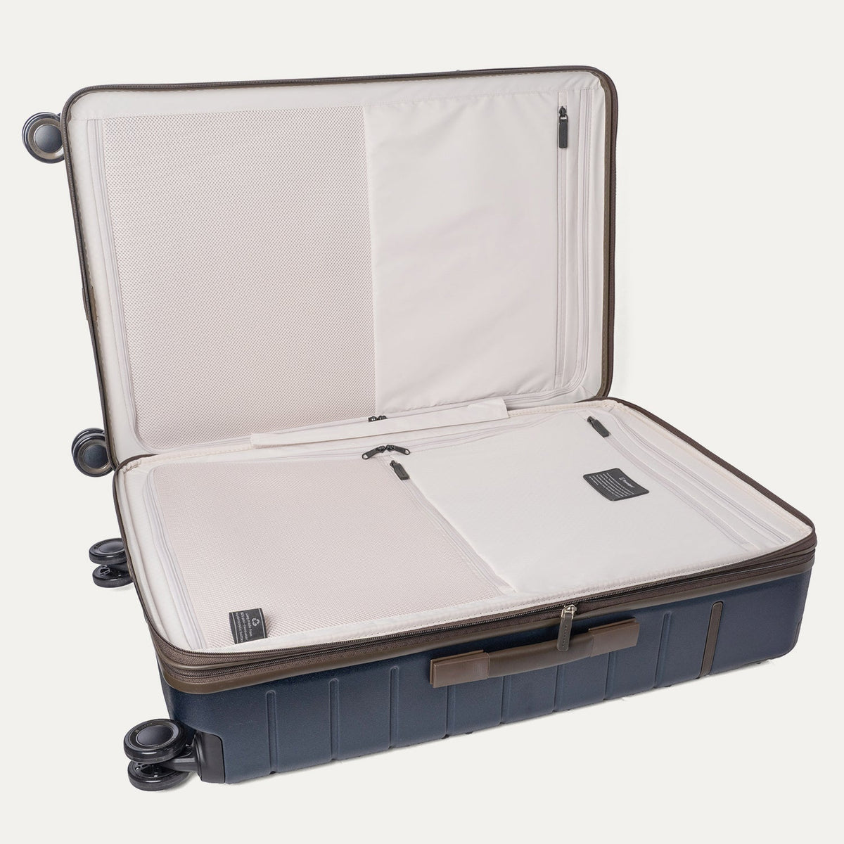 Open interior of the Travelpro Platinum Reserve Large Check-In Hardshell Spinner in Midnight Trail showing the zippered divider panel and dedicated pockets