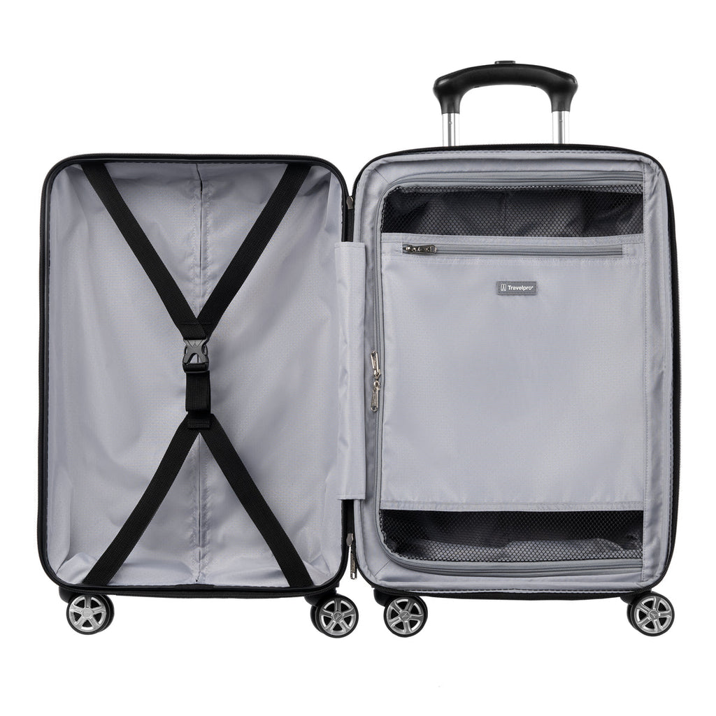 Interior view of hardside spinner with zippered divider panel and cross straps for organized packing.
