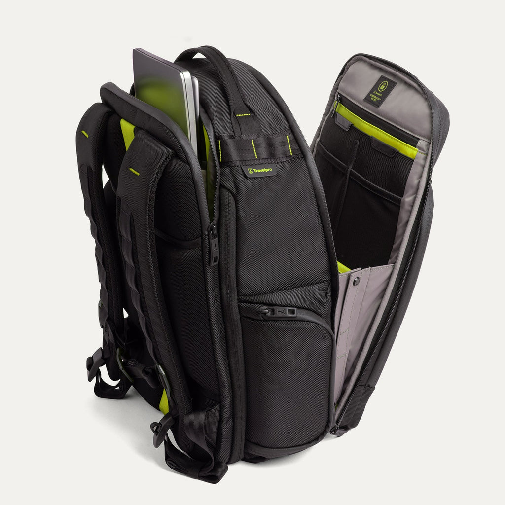 Three‑quarter rear view of the Travelpro Altitude Large Backpack in Neon Shadow, showing black textured exterior with neon yellow accents, open main compartment with gray lining, and multiple zippered pockets against a light background.