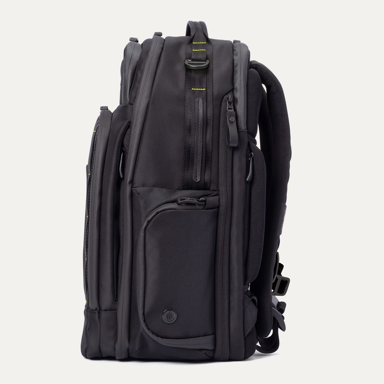 Side profile view of the Travelpro Altitude Large Backpack in Neon Shadow, showing black textured exterior with neon yellow accent panel, multiple zippered pockets, and padded shoulder straps against a light background.