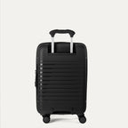 Black suitcase with wheels on a light gray background