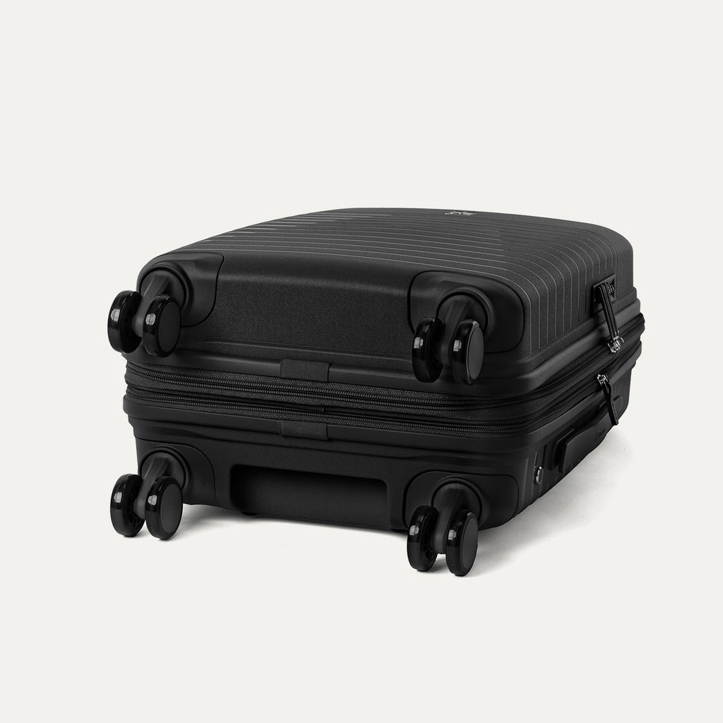 Black suitcase with wheels on a light gray background