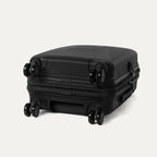 Black suitcase with wheels on a light gray background