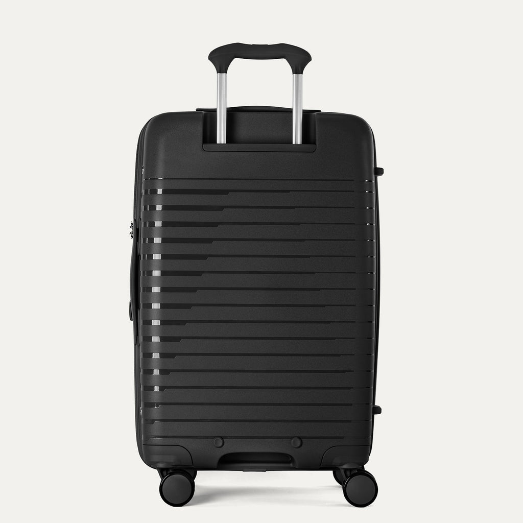 Black suitcase with a ribbed texture on a light gray background