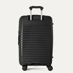 Black suitcase with a ribbed texture on a light gray background