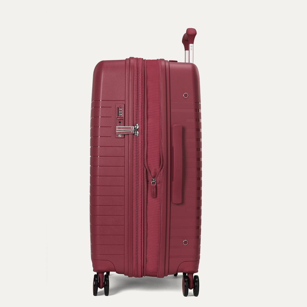 Red suitcase with wheels on a light gray background