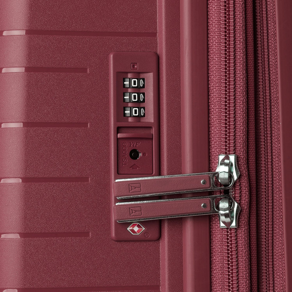 Close-up of a burgundy suitcase with a combination lock and zipper.