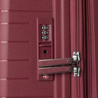Close-up of a burgundy suitcase with a combination lock and zipper.